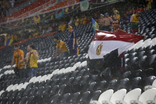 Fan holds a flag of Egypt while standing in the rain after the Group D Euro 2012 soccer match between Ukraine and France was suspended because of the weather at the Donbass Arena in Donetsk