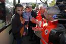 The President of the French Red Cross, Jean-Jacques Eledjam (2R) and members welcome some migrants coming from Germany, on September 9, 2015 before settling them at the Armade student residence in Champagne-sur-Seine
