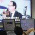A foreign exchange trader looks at a television showing the result of French Presidential election at a foreign currency trading company in Tokyo