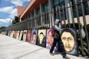 A student walks past portraits of some of the 43 missing students from Ayotzinapa, in front of the Congress of the state of Guerrero in Chilpancingo, Mexico on September 24, 2015
