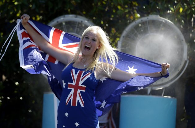 A spectator holds the Australian flag at the Australian Open tennis championship. (AP Photo/Aijaz Rahi)