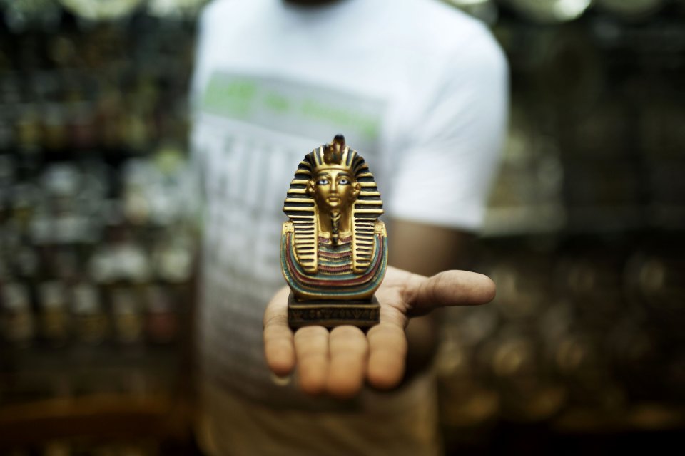 Romi, 26, displays one of the items offered for sale at his souvenir store in the Khan El-Khalili market, a popular destination for tourists, in Cairo, Egypt, Wednesday, Aug. 21, 2013. Riots and killings that erupted across the country after the crackdown against followers of ousted President Mohammed Morsi have delivered a severe blow to Egypt's tourism industry, which until recently accounted for more than 11 percent of the country's gross domestic product and nearly 20 percent of its foreign currency revenues. (AP Photo/Manu Brabo)