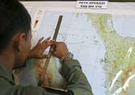 An Indonesian Air Force officer draws a flight pattern flown earlier in a search operation for the missing Malaysia Airlines Boeing 777, during a post-mission briefing at Suwondo air base in Medan, North Sumatra, Indonesia, Thursday, March 13, 2014. The hunt for the missing jetliner has been punctuated by false leads since it disappeared with 239 people aboard about an hour after leaving Kuala Lumpur for Beijing early Saturday. (AP Photo/Binsar Bakkara)