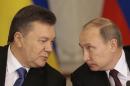 Russian President Vladimir Putin, right, and his Ukrainian counterpart Viktor Yanukovych chat during a news conference after their talks in Moscow on Tuesday, Dec. 17, 2013. Russian President Vladimir Putin says Moscow has agreed to sharply cut the price of its natural gas supplies to Ukraine and will buy $15 billion worth of Ukrainian government bonds, but says there was no discussion about Ukraine joining a free trade pact of three ex-Soviet nations. (AP Photo/Ivan Sekretarev)