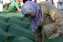 Bosnian Muslim woman weeps while she touches a coffin of her relative among the over five-hundred coffins displayed at the Potocari memorial cemetery near Srebrenica, some 160 kilometers east of Sarajevo, Bosnia, Wednesday, July 11, 2012. Thousands gathered in the cemetery for the mass burial of 520 bodies, marking 17th anniversary of the Srebrenica massacre. (AP Photo/Sulejman Omerbasic)