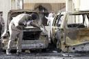 Policeman carries out an inspection after a car exploded near a Shi'ite mosque in Saudi Arabia's Dammam