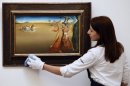 Una empleada de Sotheby's, junto a otra obra de Dalí
