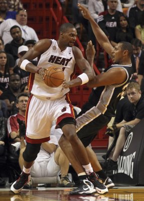 Miami Heat center Chris Bosh is guarded by San Antonio Spurs center Boris Diaw during their NBA basketball game at the American Airlines Arena in Miami