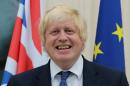 British Foreign Secretary Boris Johnson stands between a Union FLag and a European Union (EU) flag during a reception at the French Ambassador's residence in west London on July 14, 2016