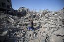Palestinians walk amid the rubble of destroyed buildings and homes in the Shejaiya residential district of Gaza City on July 26, 2014