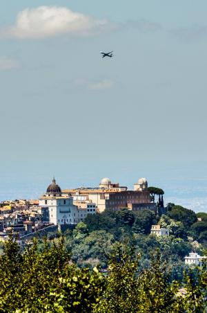 A plane flies over the telescope domes of the Vatican …