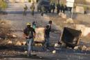 Palestinian protester runs during clashes with the Israeli troops near the Jewish settlement of Beit El, near the West Bank city of Ramallah