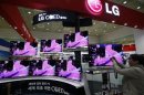 A visitor takes a photograph of LG Electronics' TV set during World IT show 2013 at the Coex convention centre in Seoul May 22, 2013. REUTERS/Kim Hong-Ji