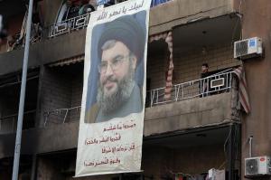 A poster of Hassan Nasrallah hangs on the balcony of …