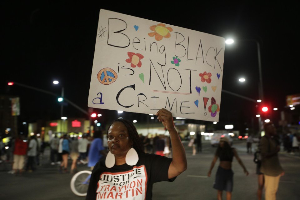 A woman holds up a sign during a demonstration in reaction to the acquittal of neighborhood watch volunteer George Zimmerman on Monday, July 15, 2013, in Los Angeles. Anger over the acquittal of a U.S. neighborhood watch volunteer who shot dead an unarmed black teenager continued Monday, with civil rights leaders saying mostly peaceful protests will continue this weekend with vigils in dozens of cities. (AP Photo/Jae C. Hong)
