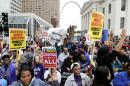 Protesters march near the St. Louis Arch, Saturday, Oct. 11, 2014, in St Louis. More than 1,000 gathered Saturday in downtown St. Louis for a second day of organized rallies to protest Michael Brown's death and other fatal police shootings in the area and elsewhere. (AP Photo/Charles Rex Arbogast)