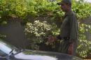A Pakistani private security guard uses an explosives detector to search a vehicle at a mall entrance in Islamabad