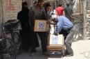 Residents of Syria's Yarmuk Palestinian refugee camp, south of Damascus, gather to collect aid food on July 14, 2014
