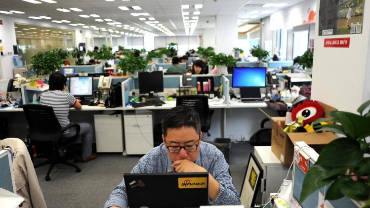 A man uses a laptop at an office of Sina Weibo, China&#39;s equivalent to Twitter, in Beijing on April 16, 2014