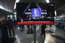 An information screen displays a message "Let Us Pray For Flight MH370", regarding the missing Malaysia Airlines flight, at Kuala Lumpur International Airport in Sepang