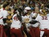 Oklahoma infielder Lauren Chamberlain, in center with batting helmet, is mobbed by her teammates following her 12th inning home run against Tennessee in the first game of the best of three Women's College World Series NCAA softball championship series in Oklahoma City, Monday, June 3, 2013. Oklahoma won 5-3 in 12 innings.(AP Photo/Sue Ogrocki)