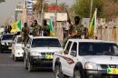 Members of Iraq's Shiite Ketaeb Hezbollah paramilitary group convoy arrives in Baghdad's Karada disctrict to deliver the body of a man believed to be Saddam Hussein's long-fugitive deputy Izzat Ibrahim al-Duri to Iraqi authorities, on April 20, 2015