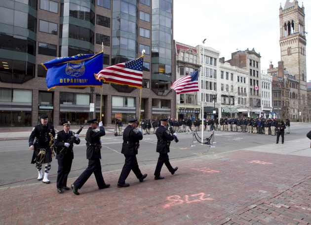Officers march into position near the blast site on Boylston Street between Dartmouth and Exeter Streets near the Boston Marathon finish line Monday, April 22, 2013 in Boston. Federal investigators formally released the finish line bombing crime scene to the city in a brief ceremony at 5 p.m. (AP Photo/Robert F. Bukaty)