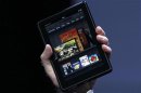 Jeff Bezos holds up the new Kindle Fire at a news conference during the launch of Amazon's new tablets in New York