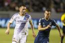 Los Angeles Galaxy forward Robbie Keane, left, moves the ball away from Vancouver Whitecaps midfielder Russell Teibert in the second half of an MLS soccer game at StubHub Center in Carson, Calif., Saturday, June 6, 2015. The Whitecaps won 1-0. (AP Photo/Ringo H.W. Chiu)