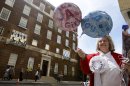 FILE - In this Monday, July 15, 2013 file photo royal supporter Margaret Tyler displays balloons for the media in front of the Lindo Wing at St Mary's Hospital in London. By the time you're reading this, the Duchess of Cambridge could be in labor. Or it could be a matter of hours. Or days. Or weeks. As Britain's Prince William and his wife, Kate, await the birth of their first child _ and the next heir to the English throne _ some are convinced the royal due date has already passed, even though the Palace has not given an exact date. Many in the British media predicted the baby would be born last week and the Prince himself is now on official leave. (AP Photo/Kirsty Wigglesworth, File)