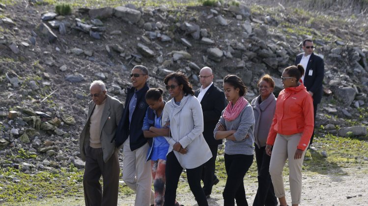 U.S. President Obama walks with his family, as they visit the rock quarry labor camp where Mandela was forced to work, while they tour Robben Island near Cape Town