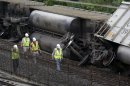 Officials walk past part of a CSX freight trail that derailed overnight in Ellicott City, Md., Tuesday, Aug. 21, 2012. Authorities said two people not employed by the railroad were killed in the incident. (AP Photo/Patrick Semansky)