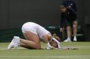Alize Cornet of France kisses the lawn after defeating Serena Williams of U.S. in the women's singles match at the All England Lawn Tennis Championships in Wimbledon, London, Saturday, June 28, 2014. (AP Photo/Sang Tan)