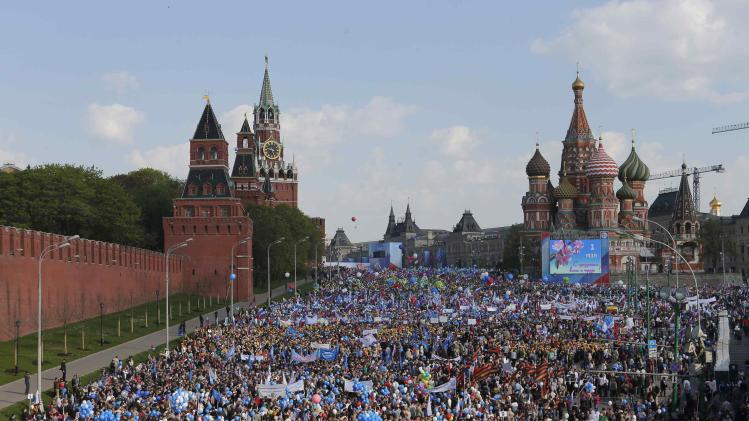 People walk with flags and balloons towards St. Basil&#39;s Cathedral on Red Square during a rally in Moscow