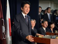 Japan's Prime Minister and leader of Liberal Democratic Party (LDP) Shinzo Abe (L) speaks to the media as he names new LDP party executives at their headquarters in Tokyo on December 25, 2012. Abe was elected as prime minister by the lower house of parliament on Wednesday