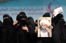 Saudi Shiite women hold placards bearing portraits of prominent Shiite Muslim cleric Nimr al-Nimr during a protest in the eastern coastal city of Qatif against his execution by Saudi authorities, on January 2, 2016