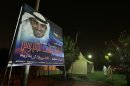 Supporters are seen walking next to a campaign banner of Osama Yousif Al-Tahoos, candidate from Third District, Kuwait City