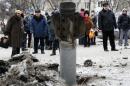 People look at the remains of a rocket shell on a street in the town of Kramatorsk