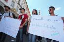 Refugees, some of whom come from Syria, and their supporters demonstrate with posters written with 'we love peace' , right, and 'they aren't acting in my name' in downtown Wuerzburg, Germany, Wednesday July 20, 2016. They are responding to the attack by a suspected Afghan refugee who attacked and critically injured passengers with an axe and knife in a regional train near Wuerzburg, (Karl-Josef Hildenbrand/dpa via AP)