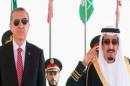 Turkish President Recep Tayyip Erdogan (left) and Saudi King Salman listen to their national anthems during a ceremony in Riyadh, on March 2, 2015