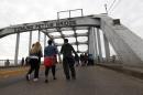 People walk along the Edmund Pettus Bridge before the beginning of the 50th anniversary of the Selma to Montgomery civil rights march in Selma