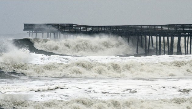 Waves crash on shore from high surf ahead of Hurricane Sandy at the pier at Virginia Beach, Virginia