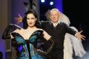 French fashion designer Jean-Paul Gaultier, right, rushes towards burlesque artist Dita Von Teese at the end of his Spring-Summer 2014 Haute Couture fashion collection, presented Wednesday, Jan. 22, 2014 in Paris. (AP Photo/Jacques Brinon)