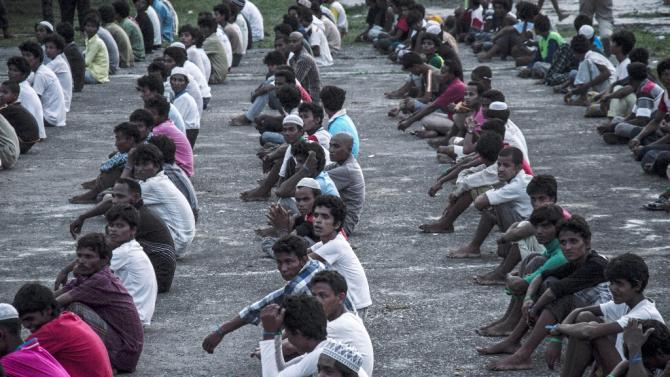 New arrivals sit in lines at a newly set up confinement area in Bayeun on May 21, 2015, after more than 400 migrants from Myanmar and Bangladesh were rescued by Indonesian fishermen off the coast of Aceh province a day earlier
