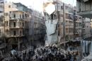 People search for survivors amidst the rubble following an airstrike in the Shaar neighborhood of Aleppo on December 17, 2013