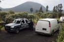 Vans belonging to Mexican authorities arrive at the entrance of a ranch where a mass grave was found in Tlalmanalco, Mexico, Thursday, Aug. 22, 2013. Mexican authorities said Thursday that they have found a mass grave east of Mexico City and are testing to determine if it holds some of the 12 people who vanished from a bar in an upscale area of the capital nearly three months ago. (AP Photo/Ivan Pierre Aguirre)