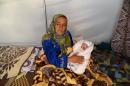 Sultan Muslim (C) poses with her newborn son, Muhammed Obama Muslim, at Suruc Rojava refugee camp in Sanliurfa on October 22, 2014