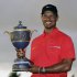 Tiger Woods holds the Gene Sarazen Cup for winning the Cadillac Championship golf tournament on Sunday, March 10, 2013, in Doral, Fla.  (AP Photo/Wilfredo Lee)