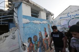 Palestinian walk by a damaged classroom at the Abu &hellip;