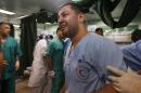 A Palestinian medic is overwhelmed by emotion as he takes a break treating wounded people by Israeli strikes, at the emergency room of the Kamal Adwan hospital in Beit Lahiya, Saturday, July 19, 2014. According to the hospital, there were more than 35 wounded Palestinians from different Israeli strikes that arrived at the hospital Saturday -- five with serious wounds, and three were dead on arrival. A health official said Saturday's strikes raised the death toll from the 12-day offensive to more than 330 Palestinians, many of them civilians and nearly a fourth of them under the age of 18. (AP Photo/Lefteris Pitarakis)